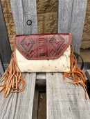 Cowhide purse with Brown leather embossed flap and tassel detail. Has a removable, adjustable shoulder strap and a wristlet strap. Front View Q