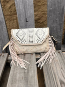 This cowhide and Beige leather bag features fringe sides and can be used as a wristlet or crossbody. It has a geometric print debossed flap with a whipstitch border.  Front View L