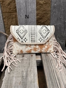 This cowhide and Beige leather bag features fringe sides and can be used as a wristlet or crossbody. It has a geometric print debossed flap with a whipstitch border.  Front View N