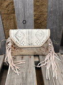 This cowhide and Beige leather bag features fringe sides and can be used as a wristlet or crossbody. It has a geometric print debossed flap with a whipstitch border.  Front View O