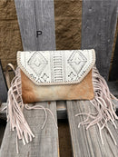 This cowhide and Beige leather bag features fringe sides and can be used as a wristlet or crossbody. It has a geometric print debossed flap with a whipstitch border.  Front View P