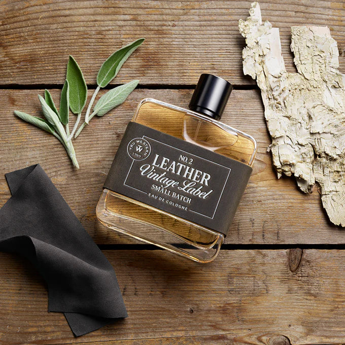 Cologne bottle 'No. 2 Leather Vintage Label' showing sage, white wood, and grey suede examples of fragrance notes. 
