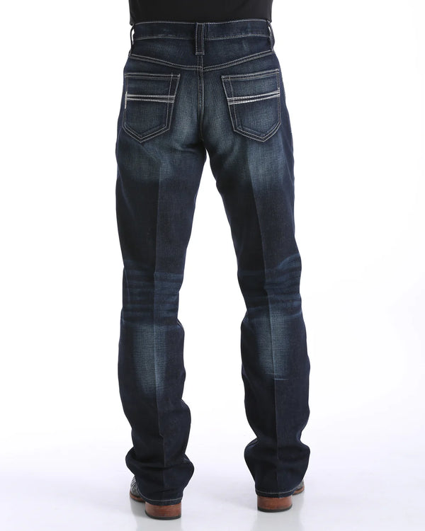 Men's Carter Dark Wash jeans back view showing detail of back pockets, belt loop placement, relaxed fit in seat and leg, boot cut stack on boots.