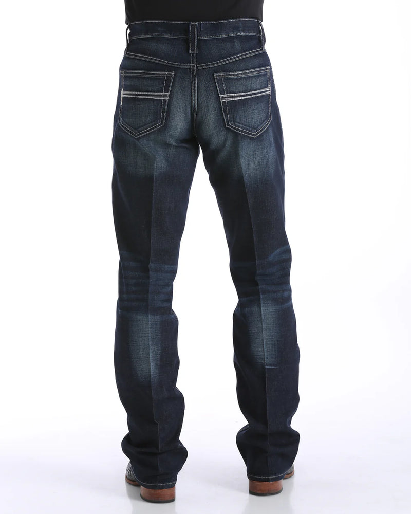 Men's Carter Dark Wash jeans back view showing detail of back pockets, belt loop placement, relaxed fit in seat and leg, boot cut stack on boots.