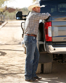 Lifestyle photo showing right side of Cinch White Label Medium Wash jeans.