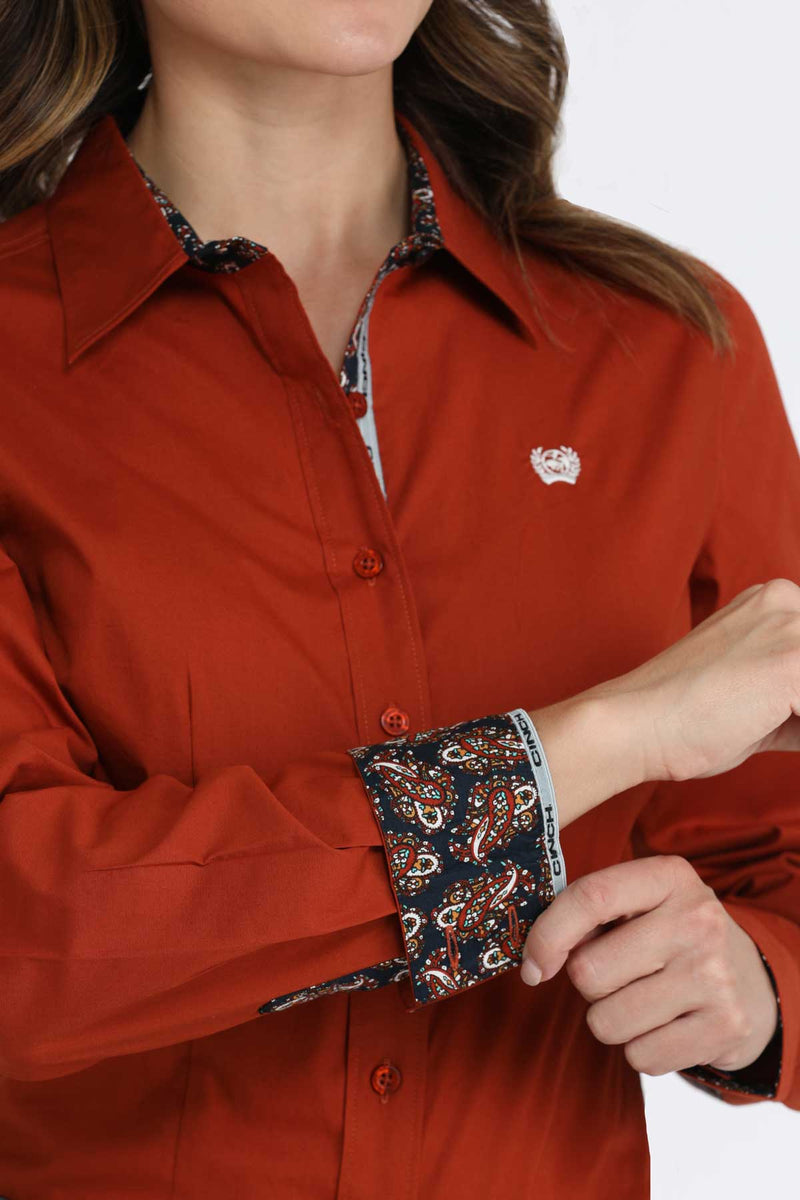 Closeup view of contrast lining fabric of cuff, collar, and front button placket. Also shows closeup of white left chest logo embroidery.