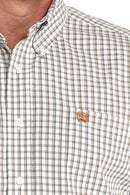 Close-up of a tan plaid shirt with a tan embroidered logo (left chest) on a white background, white front buttons, and button down collar.