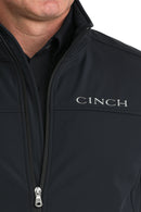 Cinch black nylon-spandex ripstop jacket showing closeup front view of lined standing collar and full front zipper with Cinch block logo embroidered on straight shoulder yoke on left chest. 