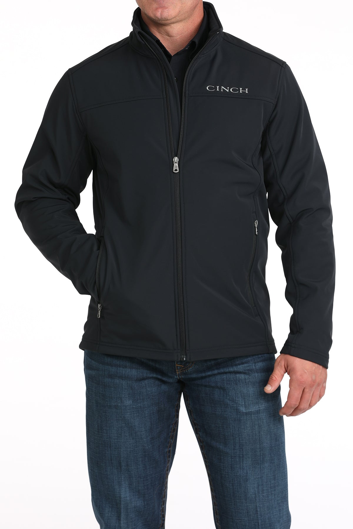 Cinch black solid nylon-spandex ripstop jacket. Has standing collar with soft lining, full front zipper with lining, zippered slash hand pockets, and Cinch block logo embroidered on left chest. Hemmed cuffs and bottom band. Hits low hip. Front view.