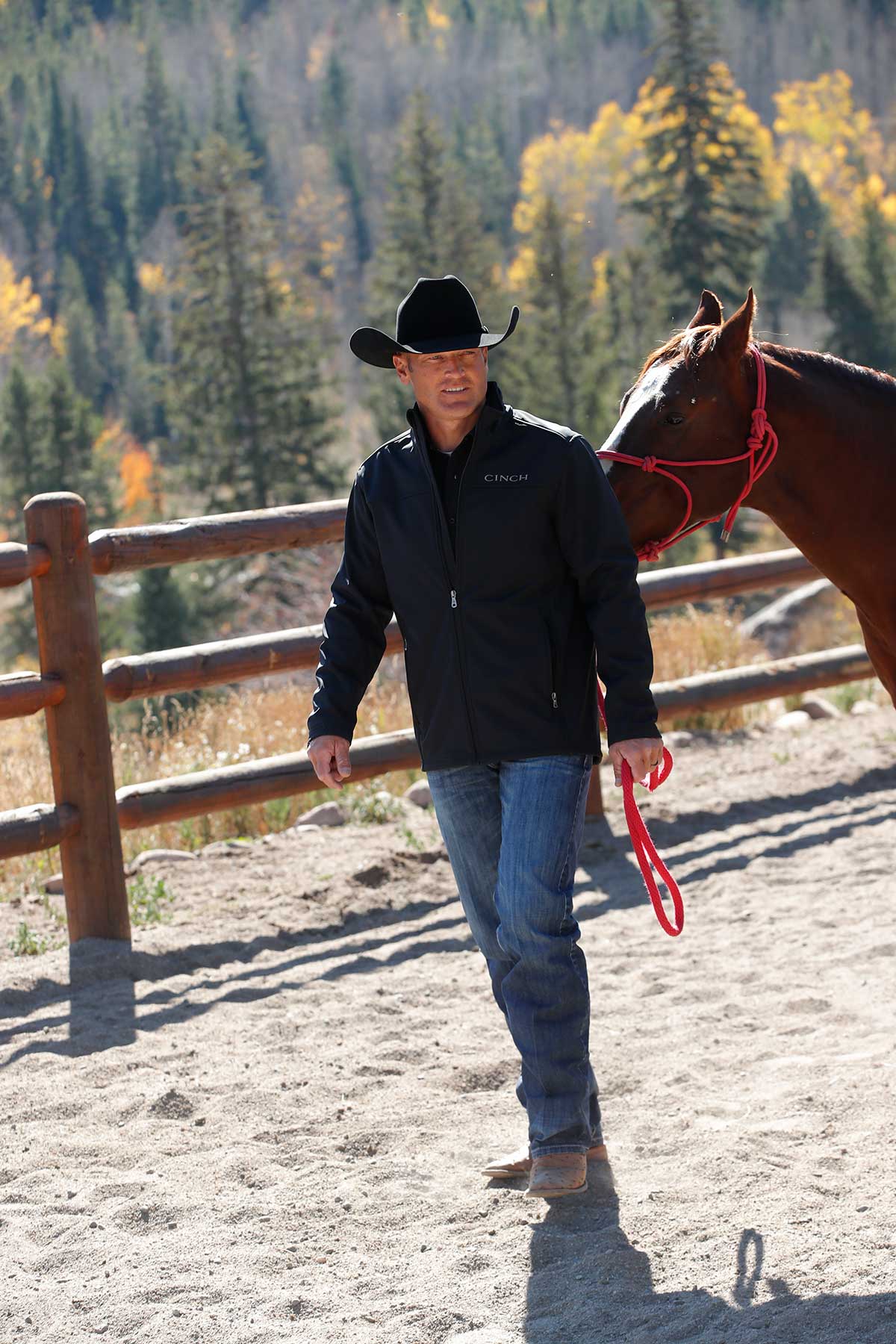 Lifestyle photo of Cinch black nylon-spandex ripstop jacket. Hits mid thigh. Front view.