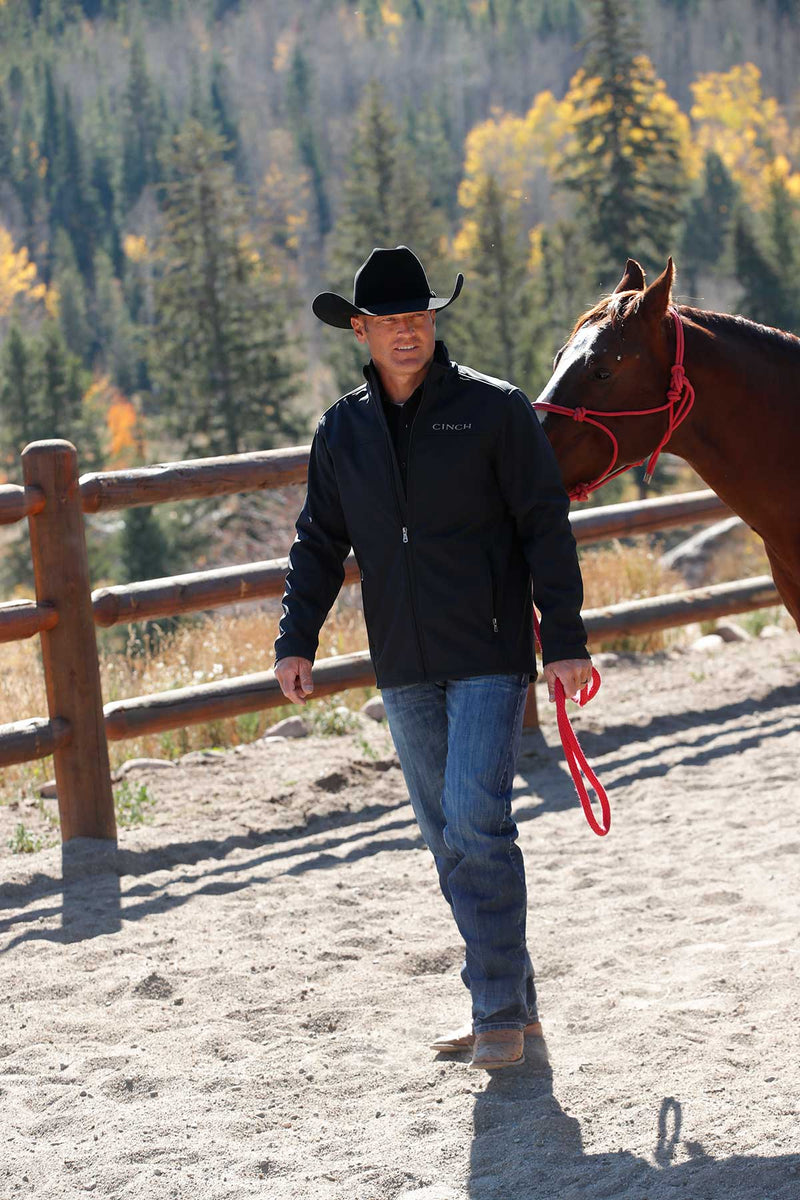 Lifestyle photo of Cinch black nylon-spandex ripstop jacket. Hits mid thigh. Front view.