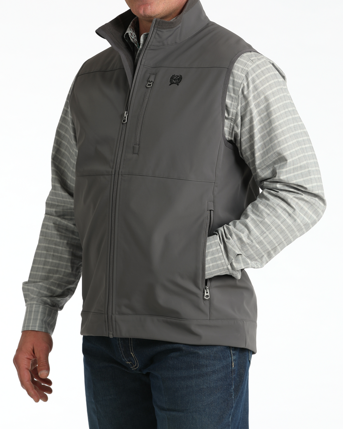  Cinch charcoal grey nylon-spandex ripstop windproof vest. Has full front zipper, slash zippered hand pockets, left chest vertical zippered phone pocket, left chest black embroidered logo, lined standing collar. Has zipper wind liner. Hits low hip. Side View 