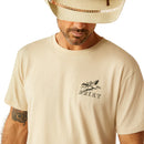 Men's Ariat short sleeve graphic tee in Natural. Close up of left chest graphic showing Bronc rider and Ariat logo. 