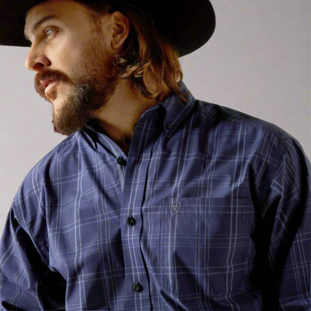 Men's Ariat long sleeve classic fit shirt in Navy.  Close up of chest pocket showing Ariat shield logo. 