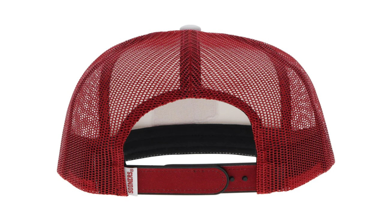 Red and white snapback cap with Oklahoma state outline and OU logo patch. Rear view stock photo showing red mesh back, red snapback and small tag with Sooners.