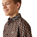 Boy's Ariat long sleeve team logo shirt in brown with a blue diamond pattern. Close up of Ariat logo on button down collar and Ariat shield logo on left chest pocket. 