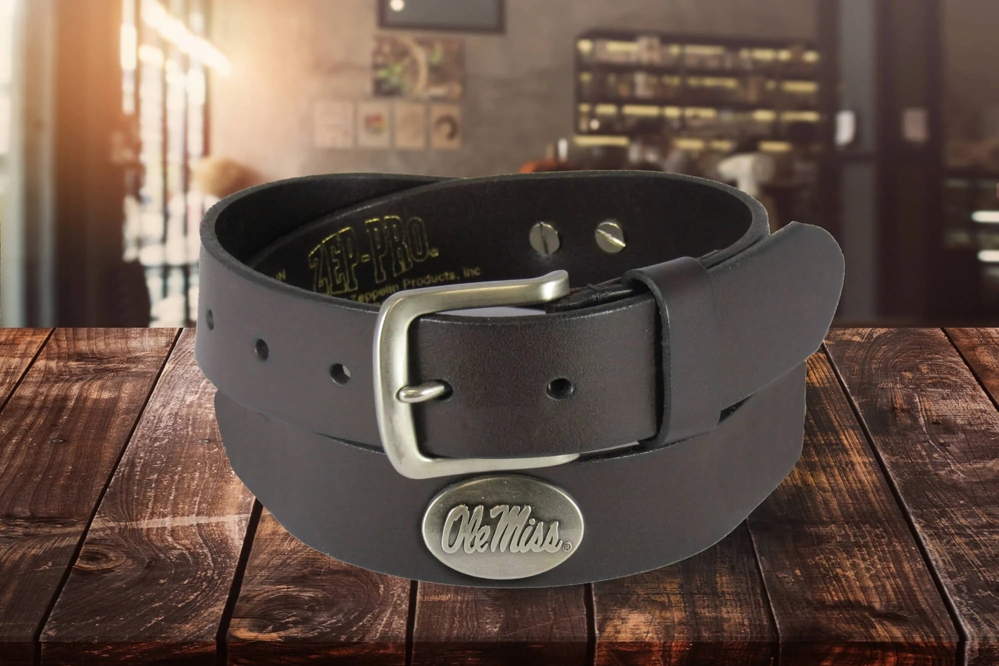 A Zep-Pro kids' brown leather belt with a silver metal buckle and oval Ole Miss silver tone concho. 