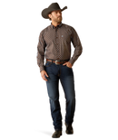 Men's Ariat long sleeve team logo shirt in brown with a blue diamond pattern. Full front view showing shirt tucked in.