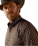 Men's Ariat long sleeve team logo shirt in brown with a blue diamond pattern. Close up of Ariat logo on collar. 