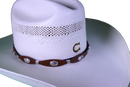 Brown leather hat band with Praying Cowboy Conchos and a western style buckle. View of buckle on straw hat. 