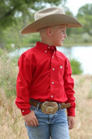 A boy wearing a red long sleeve button down shirt with an embroidered logo on the pocket.