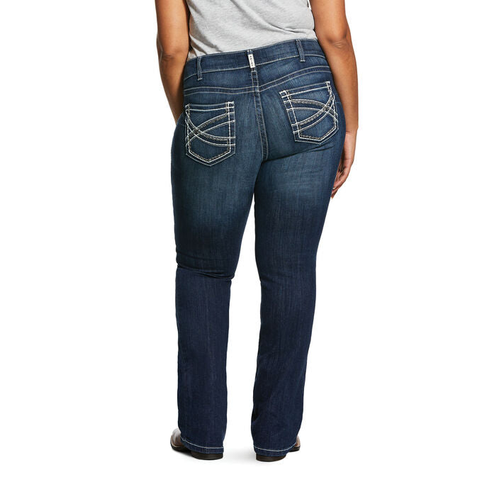 Women's Ariat mid rise boot cut jean in Marine which is a medium wash. Rear view on model.