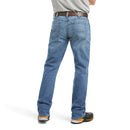 Men's Ariat Rebar M4 relaxed fit boot cut jeans in a medium wash. Rear View