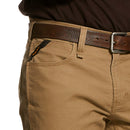 Closeup of front right with fabric closeup, front zipper tacked at stress points, and hip pocket showing additional deep coin pocket. It has angled Ariat logo ribbon from side seam to top of pocket for reinforcement. Tripled stitched opening and side seam are shown on right scoop pocket. Belt loops shown are tacked with strong stitching on the top and bottom. Carabiner loop between belt loops is hidden under belt