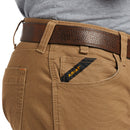 Closeup of front right of Ariat M7 Rebar pants with fabric closeup and hip pocket showing additional deep coin pocket. It has angled Ariat logo ribbon from side seam to top of pocket for reinforcement. Tripled stitched opening and side seam are shown on right scoop pocket. Belt loops shown are tacked with strong stitching on the top and bottom. Carabiner loop between belt loops is hidden under belt. 