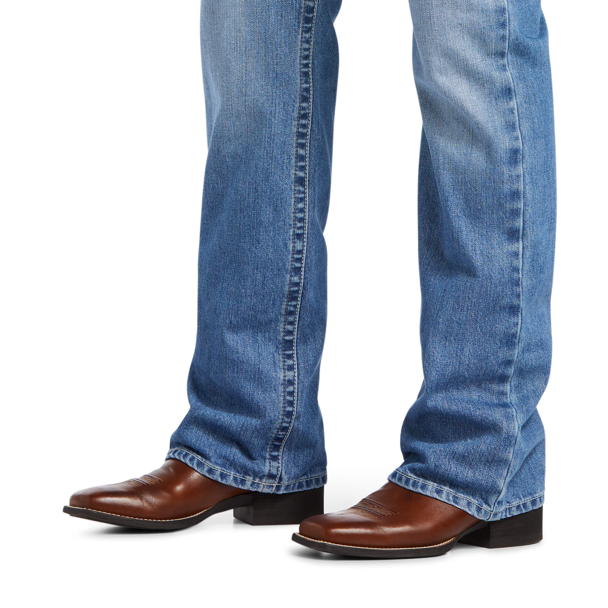 Men's Ariat M4 relaxed fit boot cut jean in a light wash.  Bottom view showing leg opening over jeans. 
