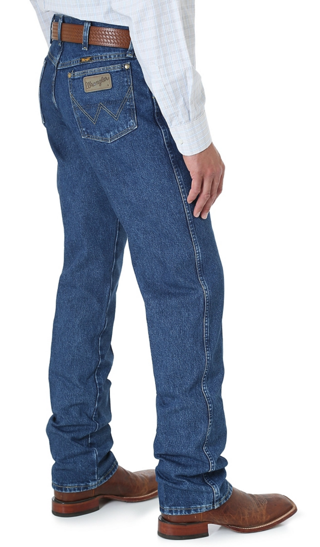 A side view of a man wearing Wrangler men's George Strait Cowboy Cut original fit jeans with a high-rise waist and a straight leg.
