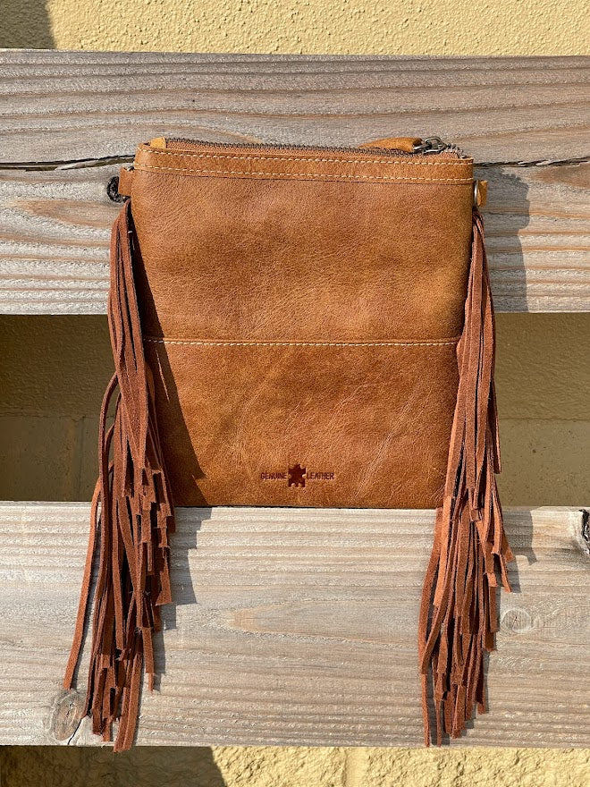 This Brown tooled leather and cowhide bag features side fringe. Rear view 