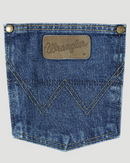 A close-up view of the back pocket of a Wrangler men's George Strait Cowboy Cut relaxed fit jeans showing the top rivets, faux leather logo patch, and the "W" stitching.