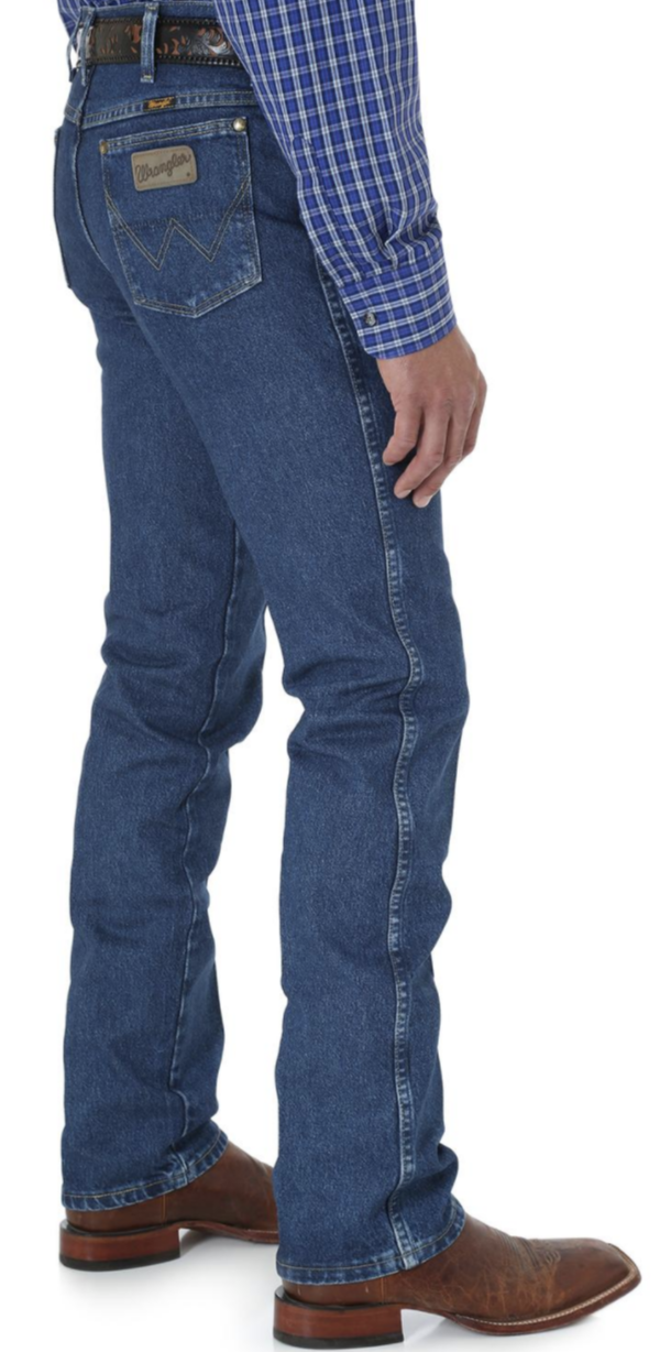 A side view of a man wearing Wrangler men's George Strait Cowboy Cut slim fit jeans with a high-rise waist and a straight leg.