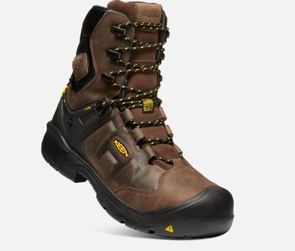 Keen Men's Dover 8 inch waterproof boots with carbon-fiber toe in Dark Earth and Black color, featuring a lace-up closure and a rubber outsole. Single boot view showing American Built Tag and Keen logo. 