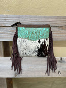 This cowhide and leather crossbody bag has fringe side details and a embossed Turquoise panel along the top front of the bag.  Front View
