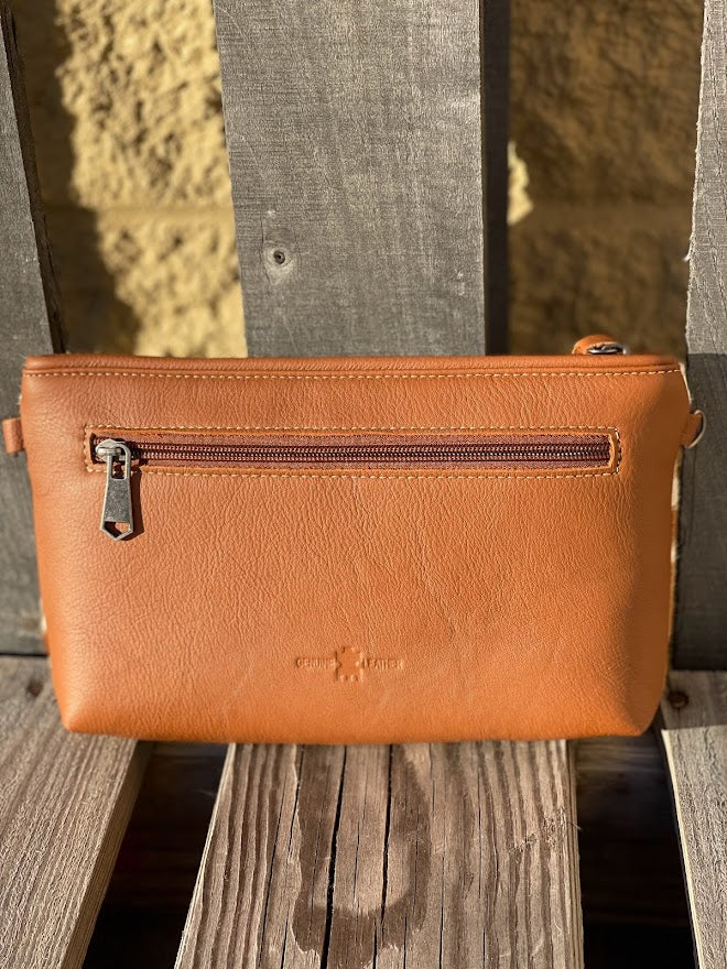 Cowhide wristlet with detachable crossbody strap with a solid Brown leather back. Rear View