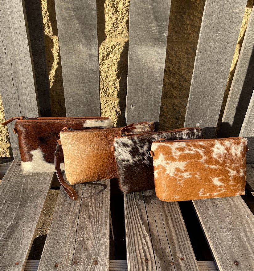 Cowhide wristlet with detachable crossbody strap with a solid Brown leather back. 
