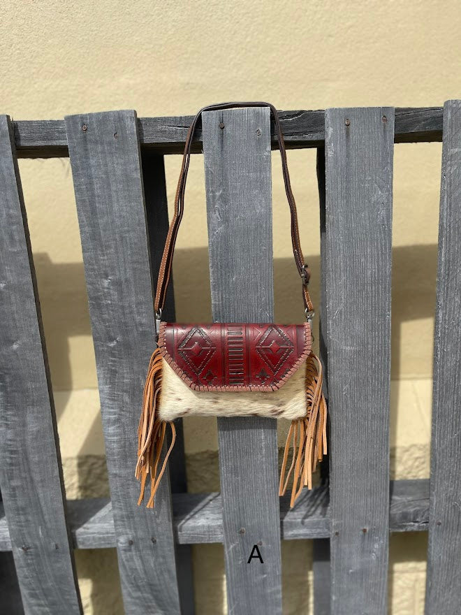 Cowhide purse with Brown leather embossed flap and tassel detail. Has a removable, adjustable shoulder strap and a wristlet strap. Front View A