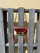Cowhide purse with Brown leather embossed flap and tassel detail. Has a removable, adjustable shoulder strap and a wristlet strap. Front View C