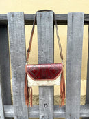 Cowhide purse with Brown leather embossed flap and tassel detail. Has a removable, adjustable shoulder strap and a wristlet strap. Front View D