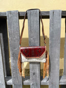 Cowhide purse with Brown leather embossed flap and tassel detail. Has a removable, adjustable shoulder strap and a wristlet strap. Front View F