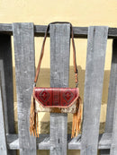 Cowhide purse with Brown leather embossed flap and tassel detail. Has a removable, adjustable shoulder strap and a wristlet strap. Front View I