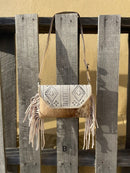 This cowhide and Beige leather bag features fringe sides and can be used as a wristlet or crossbody. It has a geometric print debossed flap with a whipstitch border.  Front View B