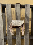 This cowhide and Beige leather bag features fringe sides and can be used as a wristlet or crossbody. It has a geometric print debossed flap with a whipstitch border.  Front View C