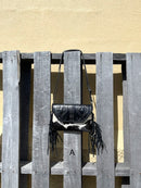 This cowhide and black leather crossbody bag has fringe sides. It features a whipstitch flap closure with a geometric design. Front View A