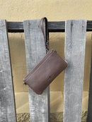 Cowhide wristlet purse in a Coffee Brown solid leather back and a zippered closure. It has a wristlet strap and a removable adjustable shoulder strap. Rear View
