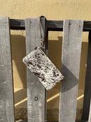 Cowhide wristlet purse in a Coffee Brown solid leather back and a zippered closure. It has a wristlet strap and a removable adjustable shoulder strap. Front View D