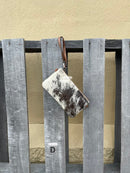 Cowhide wristlet purse with a solid Brown leather back and a zippered closure. It features a wristlet strap and and a adjustable removable shoulder strap. Front View D