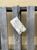 Cowhide wristlet purse in Black leather with a zippered closure. This bag has a wristlet handle or shoulder strap. Front View A